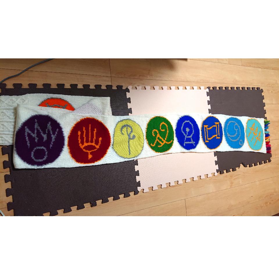 エオルゼア十二神マフラー
FINAL FANTASY XIVに登場する「エオルゼア十二神」のマークを並べたマフラーです。
2024年1月に行われたファンフェスティバルに合わせて約2週間で編みました。
裏側が見えないように筒状に編んでいます。